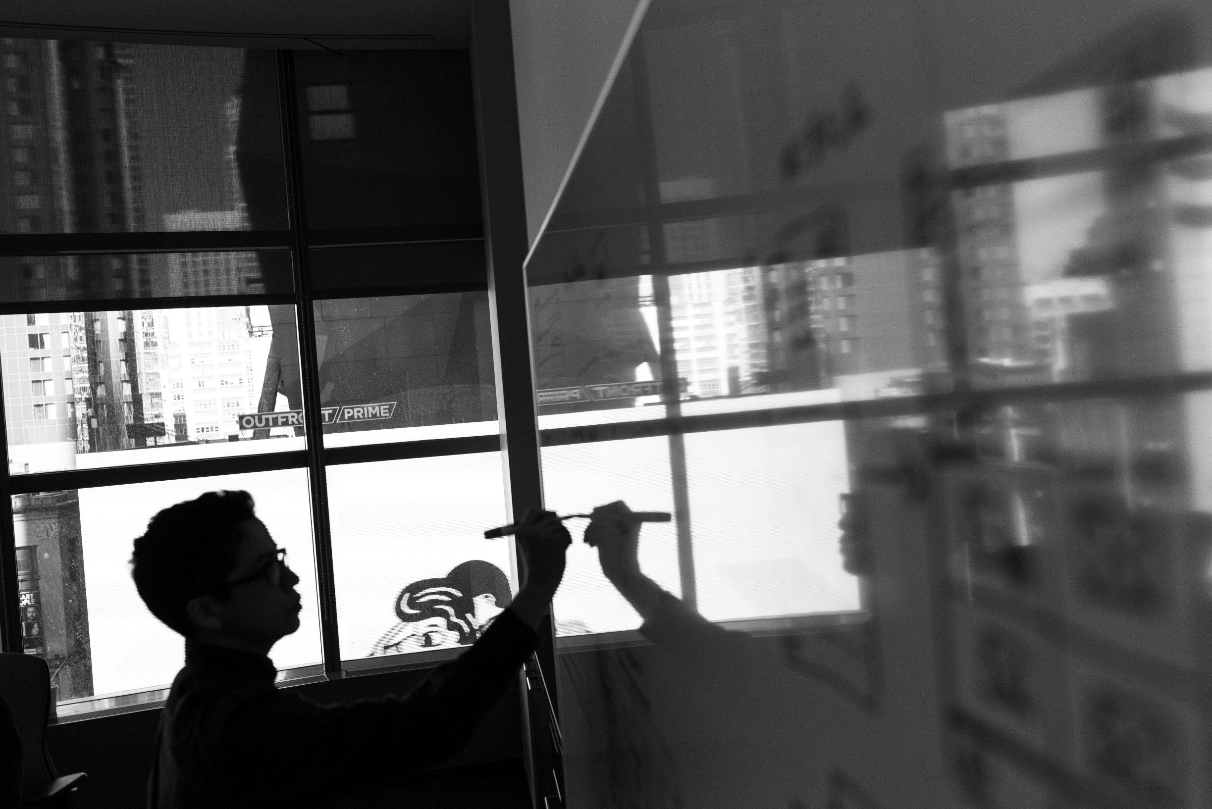 Black and white image of person brainstorming on a whiteboard